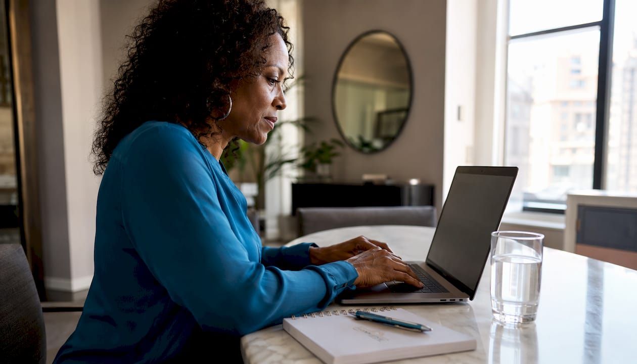 Woman researching dental implant costs at home