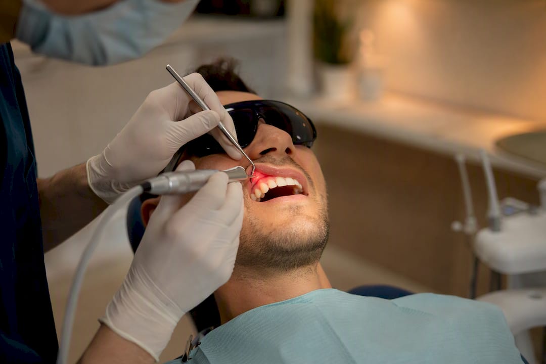 Dentist using laser for gum contouring procedure