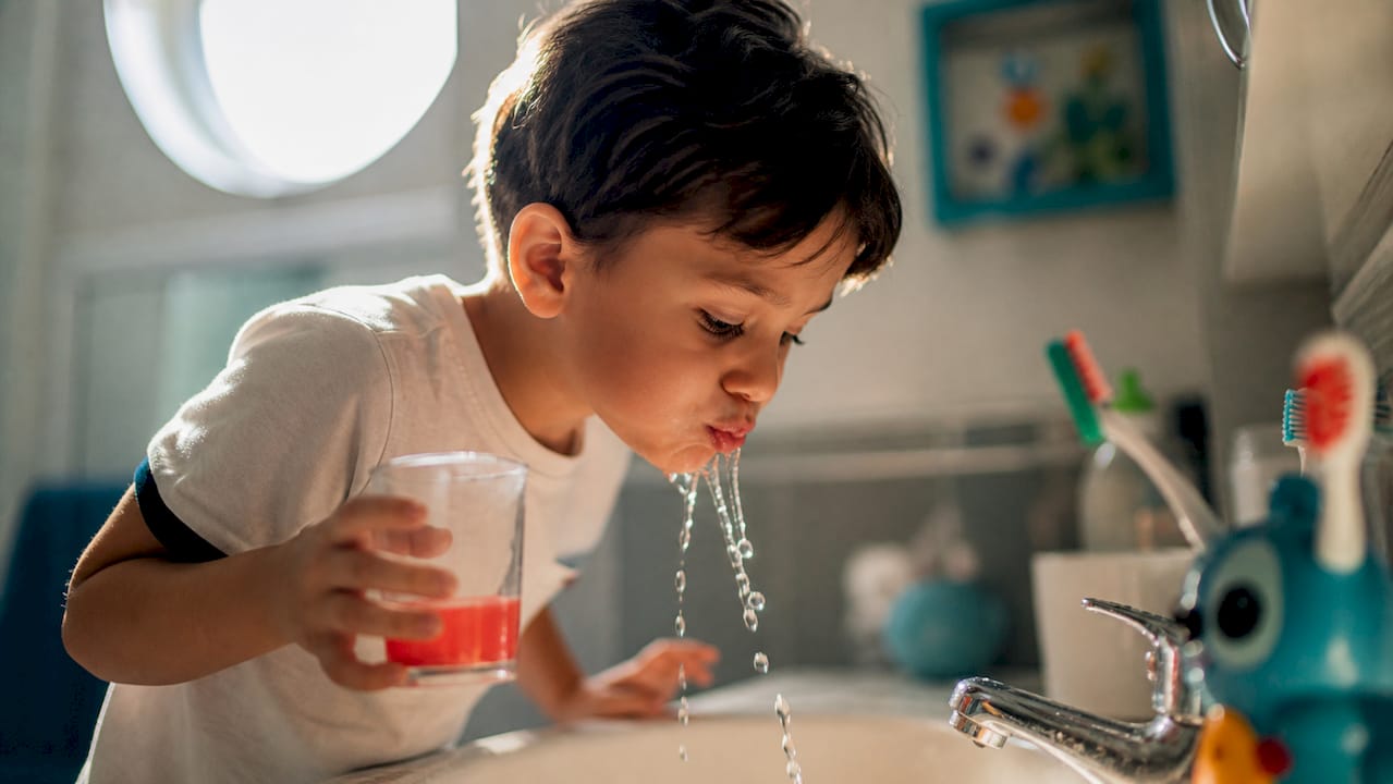 Child rinsing mouth with water